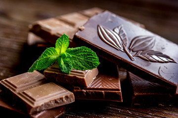 black chocolate design with mint on wooden background
