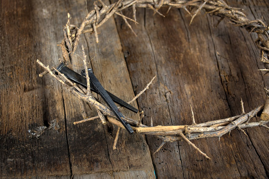 crown of thorns and rusty spikes on weathered wood