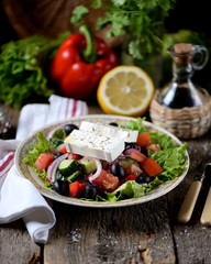 Classic Greek salad from tomatoes, cucumbers, red pepper, onion with olives, oregano and feta cheese.