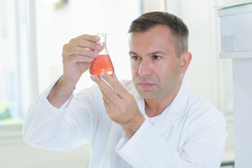 scientist inspecting the clarity of chemical