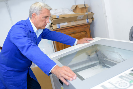 Man looking at machine with glass lid