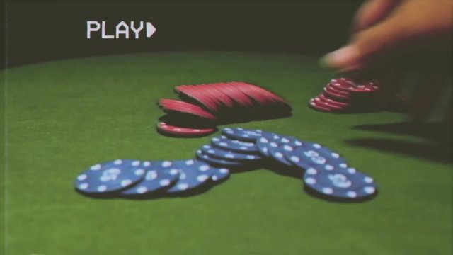 Fake VHS tape: a male hand puts rows of poker chips on a green table. Some copy space on the upper part.

