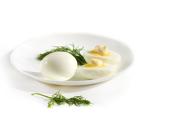 Boiled eggs in white plate against white background