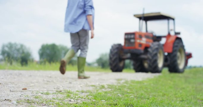 Portrait of a handsome young farmer standing in a shirt and smiling at the camera, on a tractor and nature background. Concept: bio ecology, clean environment, beautiful and healthy people, farmers.