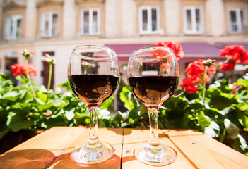 Two glasses of red wine on the vibrant restaurant background. Selective focus.