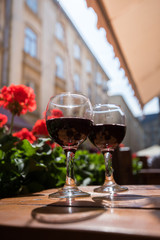 Two glasses of red wine on the vibrant restaurant background. Selective focus.