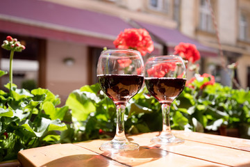 Two glasses of red wine on the vibrant restaurant background. Selective focus.