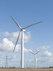Fototapeta premium Wind turbines and electricity pylons.
