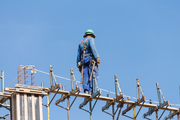 Fototapeta premium Construction worker working on top of construction site on a sunny day