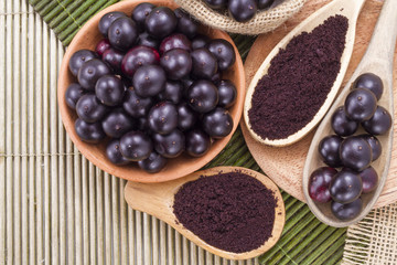 Fruits and acai powder originating from the Amazon on wood (Euterpe oleracea)