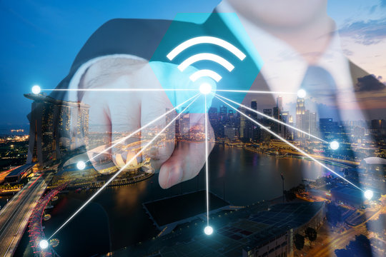 Businessman push wifi icon on city and network connection concept. Singapore smart city and wireless communication network, abstract image visual, internet of things.
