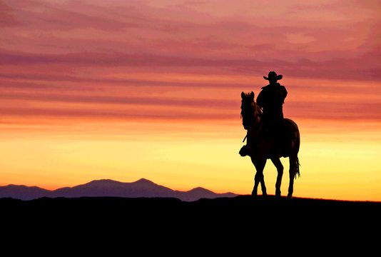 Cowboy on horse at sunset in the American West