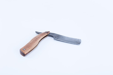 Cut throat razor forged by damascus steels with natural wood handle isolated on white background