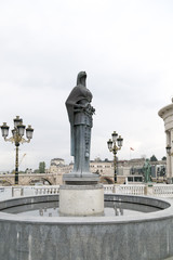 Fototapeta na wymiar Bronze sculpture of a stylized female figure holding a rosary symbol in Skopje