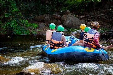 Young men and women are rafting on the river, extreme and fun sport