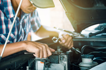 Cropped image of automobile mechanic repairing car in store, day time