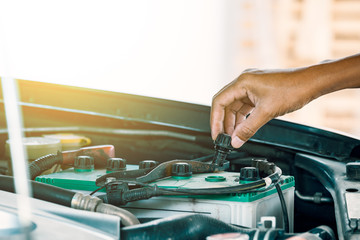 Cropped image of automobile mechanic repairing car in store, day time