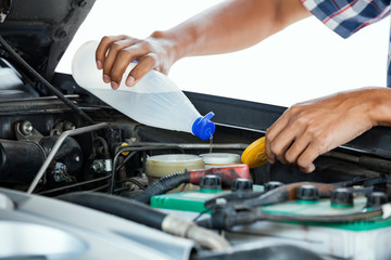 Cropped image of automobile mechanic repairing car in store, day time