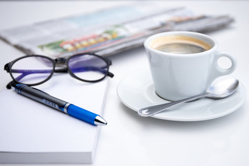 Cup of coffee in morning with notebook pen and glasses