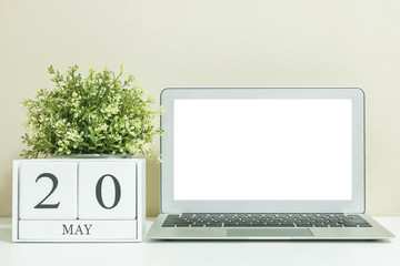 White wooden calendar with black 20 may word with white blank space at center of computer notebook...