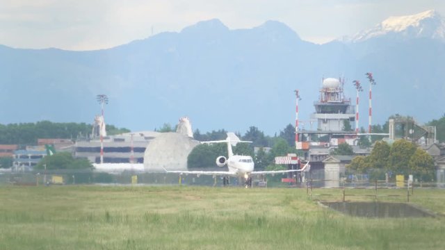 Jet Plane on Airport Takeoff Track and Mountains in the Background