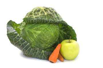 One head of a young mature cabbage garden with an apple and carrots