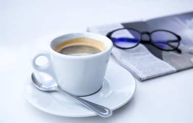 Fresh cup of coffee and news paper with glasses