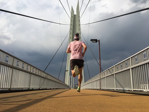 Man running over foot bridge