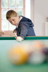 10-year-old kid learning how to play pool © goodluz