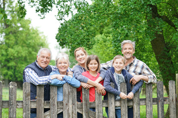 Portrait of happy family leaning on fence
