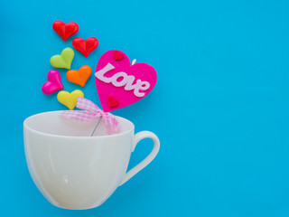 White cup with colorful of heart on Valentine's Day love concept on blue sky background