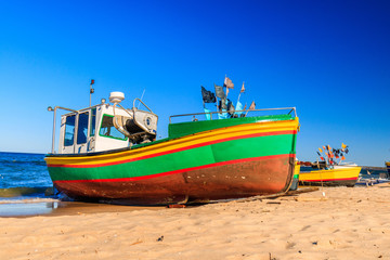 Naklejka na ściany i meble Polish vacation. Vibrant fishing boats on the sandy beach of Baltic sea in Sopot, Poland