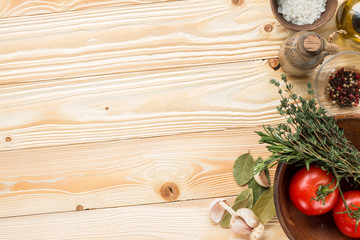 Obraz na płótnie Canvas tomatoes, herbs, thyme, rosemary, sea salt, olive oil in clay jug, garlic, pepper, bay leaf on wooden background, top view