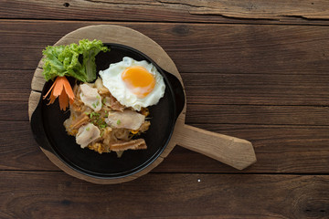 Asian noodles with fresh green onion and fried egg on old wood table