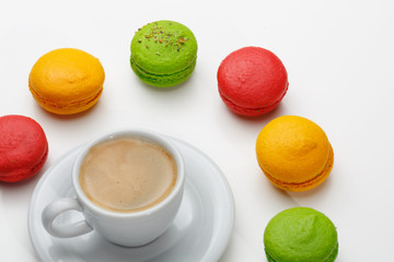 Macarons and a cup of expresso on white background. Conceptual, closeup.