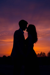 Silhouettes of couples in love at sunset.Beautiful Romantic Background. 