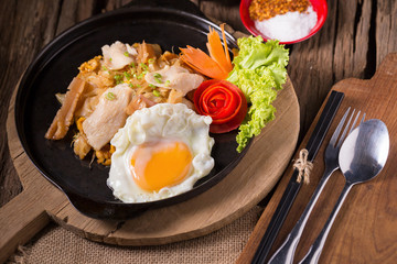 Asian noodles with fresh green onion and fried egg on old wood table