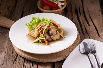 Piece of fried King Mackerel fish with fish sauce, served with spicy seafood sauce, thai style