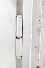 metal hinge of  old wooden windows, painted in white