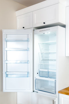 Opened new empty fridge with shelves and drawers for meat and vegetables. 