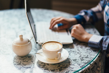 Close-up of hands of woman working in cafe table.