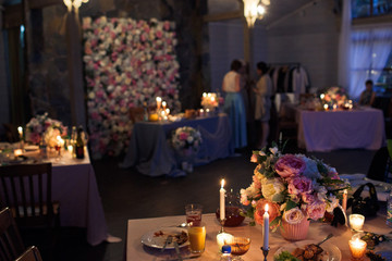 Tall candles shine before beautiful pink and white bouquet
