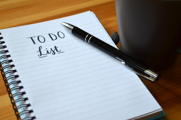 TO DO LIST handwritten on notepad on desk