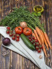 olive oil with olives and vegetables on a wooden background. 