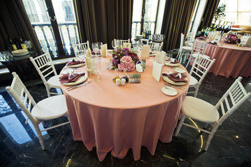 White chairs stand at pink table in the restaurant