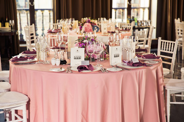 Pink dinner table served with sparkling glasses and plates