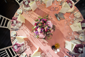 Look from above at pretty bouquet standing in the center of fancy dinner table