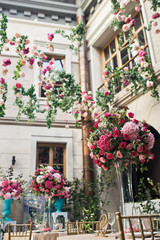 Fototapeta premium Stoły przydomowe i obiadowe ozdobione różowymi kwiatami