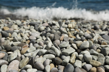 Pebble stones and with tidal bore of sea on background