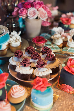 White cupcakes decorated with brown roses
